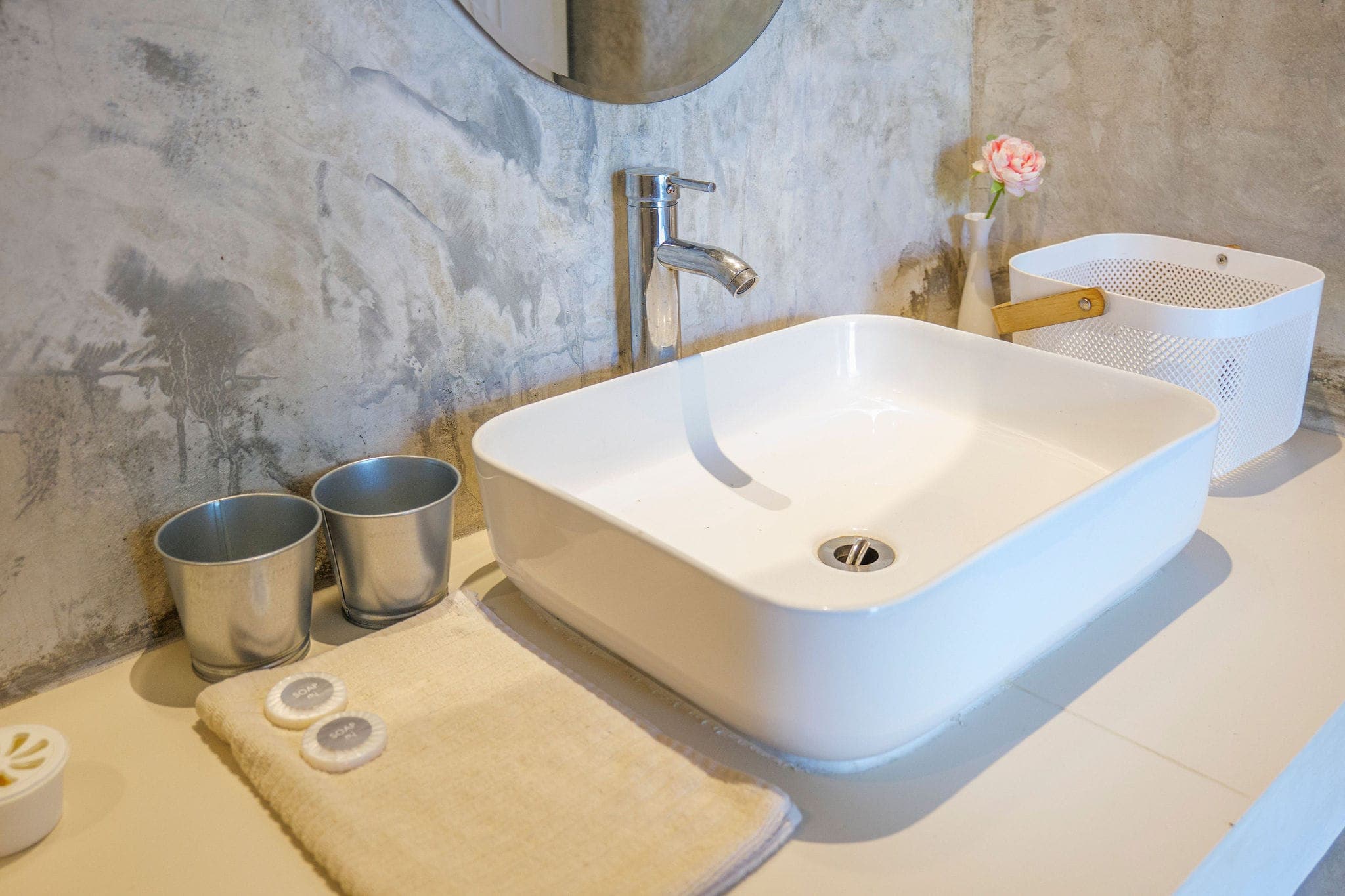 Washbasin against a polished concrete wall in the bungalow bathroom