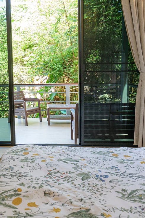 Modern Bungalow 3 — the balcony seen from the bed: bench, chair, table and jungle